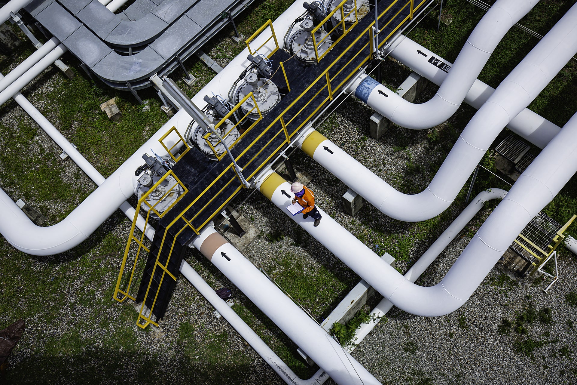 Obenansicht: Arbeiter inspiziert Ventil für visuelle Überprüfung von Rohrleitungen für Öl und Gas.